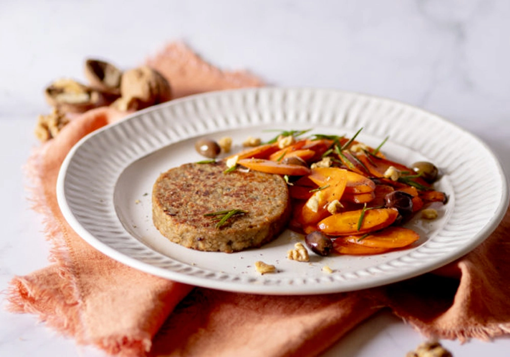 Artichoke and sundried tomato burger with carrots sautéed with olives and walnuts