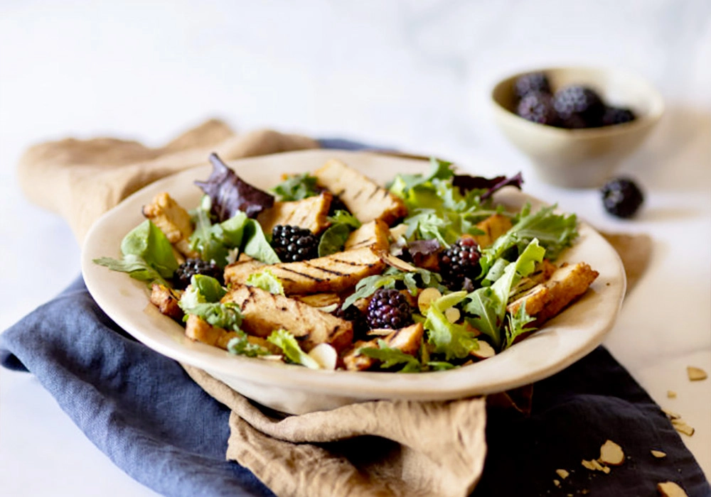 Tasty tagliata on mesclun with blackberries and almonds